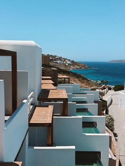 White cliffside hotel suites with private plunge pools overlooking the Mykonos coast