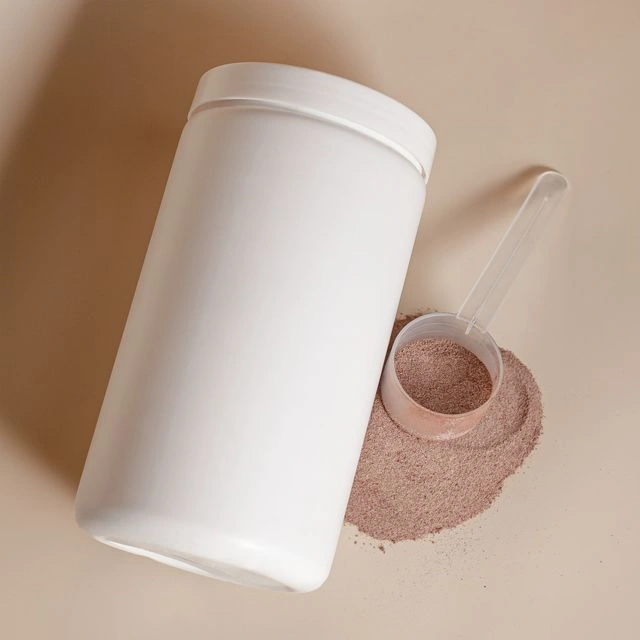 White protein powder tub with a scoop of chocolate protein powder