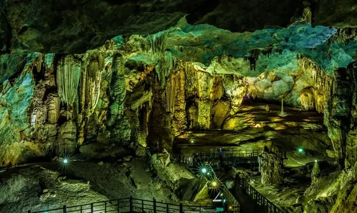 Glowing stalactites and rock formations inside a vast cave in Phong Nha, an adventurous place to visit in Vietnam