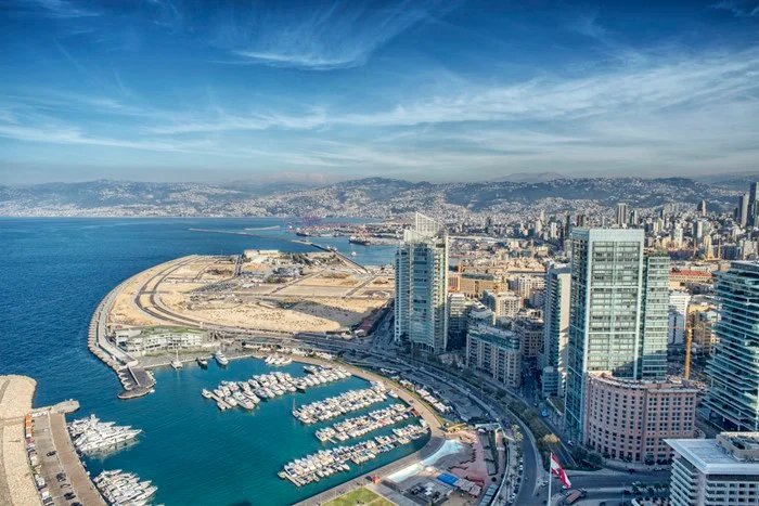 Aerial view of the Beirut waterfront in Lebanon, with yachts in Zaitunay Bay marina, high-rise towers, and mountains behind the city