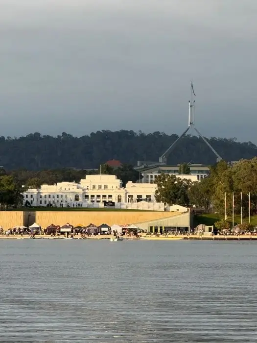 Old Parliament House and the Parliament House flagpole seen across Lake Burley Griffin, a classic view of Canberra for first-time visitors