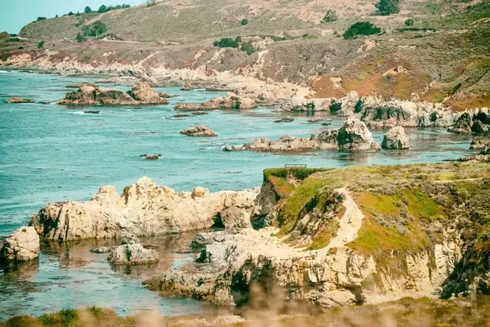 Rocky coves and turquoise tide pools along a coastal hiking trail, prime habitat for seals and seabirds on the Big Sur shoreline