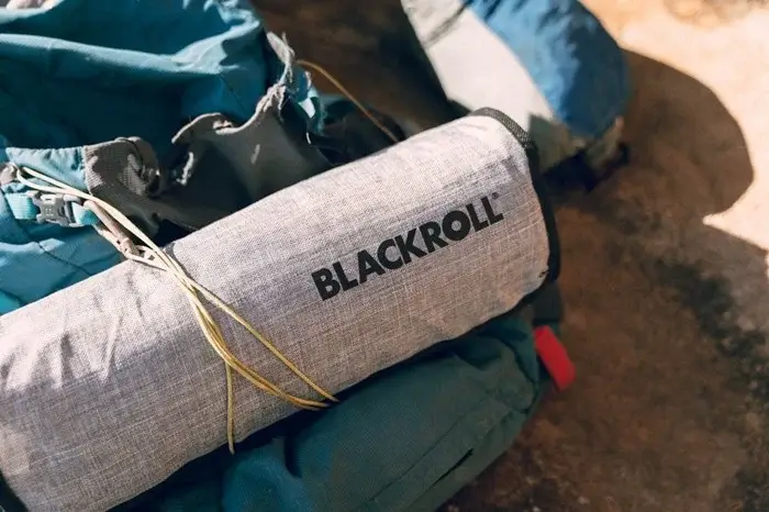 Close-up of a trekking backpack with a rolled mat secured by cord, ready for a Kilimanjaro hike