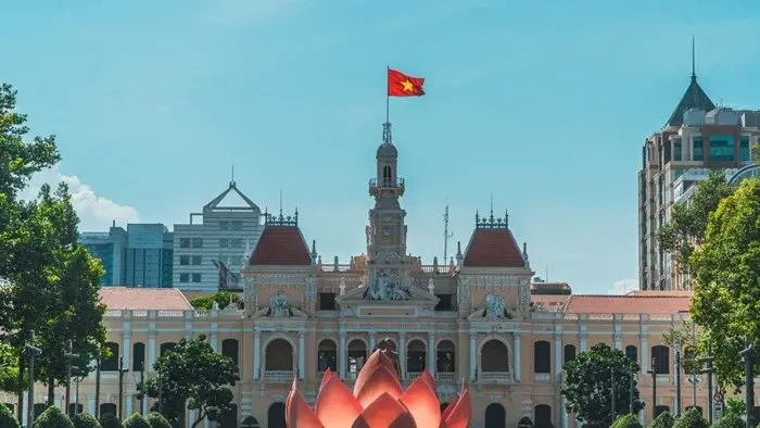 French colonial Ho Chi Minh City Hall with the Vietnamese flag on top, a historic landmark to visit in Vietnam