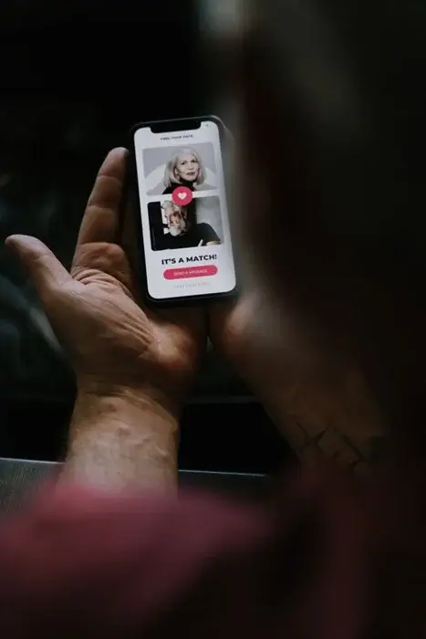 Hand holding a phone showing an “It’s a Match!” screen, the online start of international dating for slow travelers