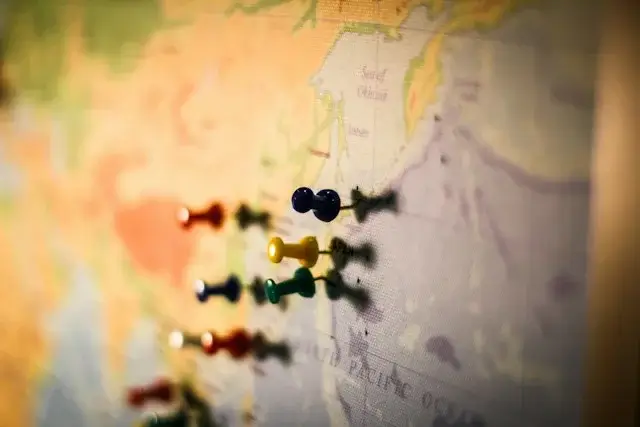 Colorful push pins on a world map near the North Pacific, marking the places a slow traveler has called home