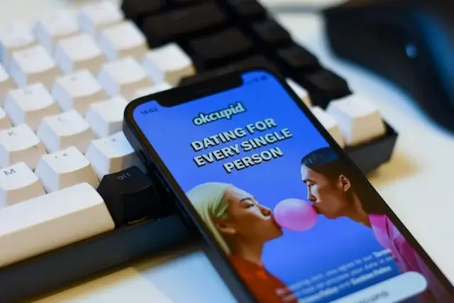 Smartphone on a keyboard showing a dating app welcome screen, where many international couples first connect online