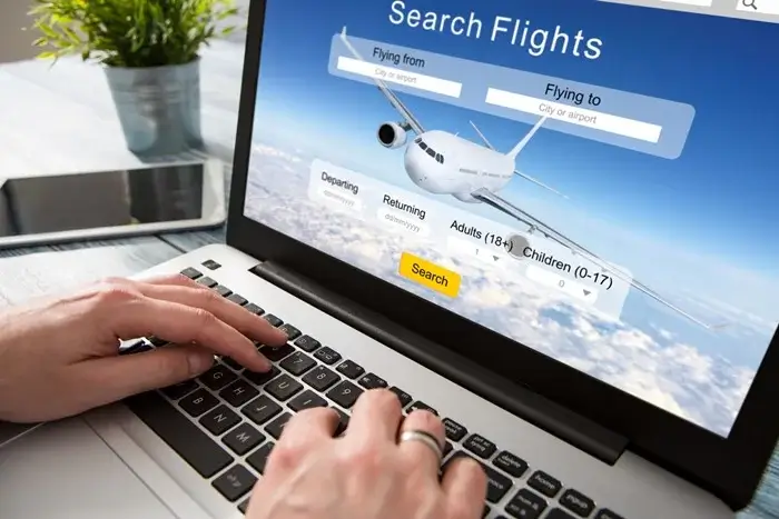 Hands typing on a laptop showing a flight search page with departure and return fields, comparing onward ticket service options for a visa application