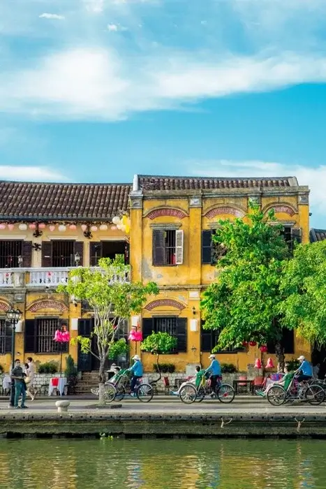 Yellow colonial-era buildings with lanterns along the Thu Bon River in Hoi An Ancient Town, a charming place to visit in Vietnam