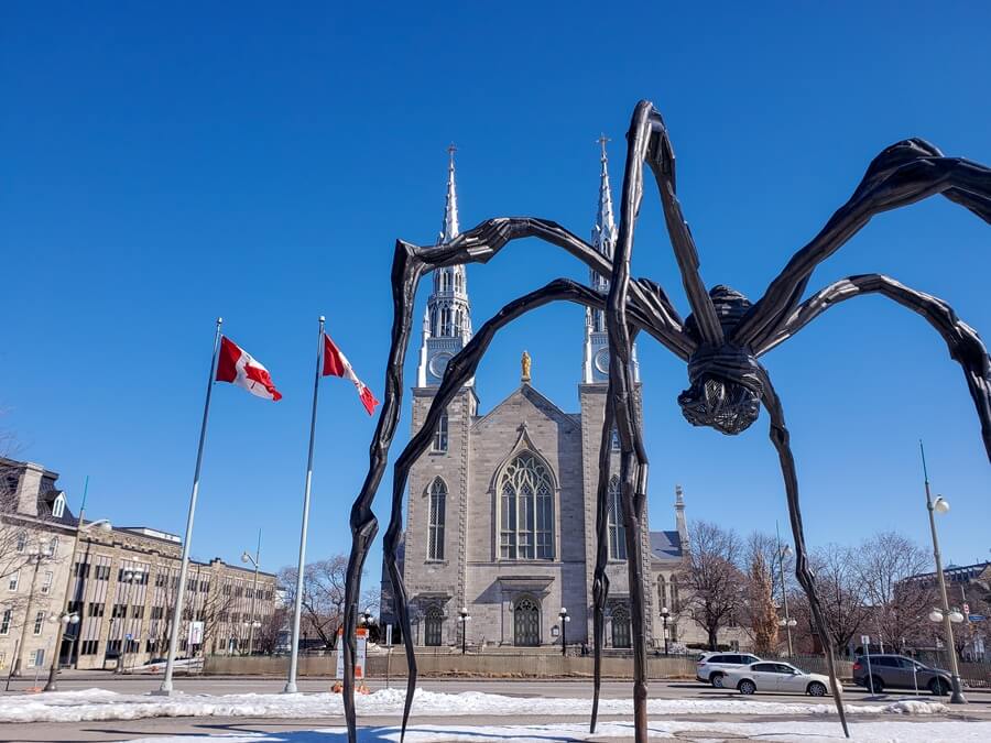 Maman sculpture with Notre Dame Cathedral in the background. 