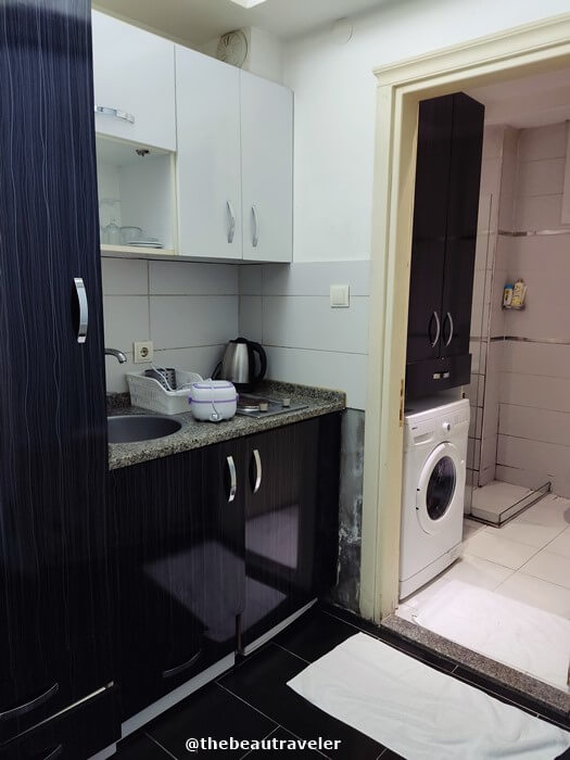 The apartment has a small kitchenette and a washing machine.