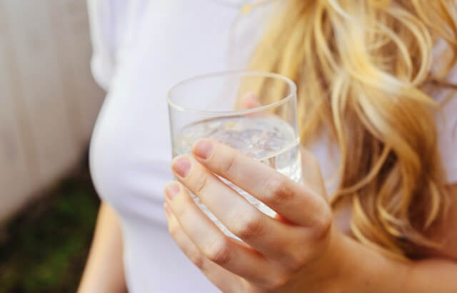 a person holding a glass of water