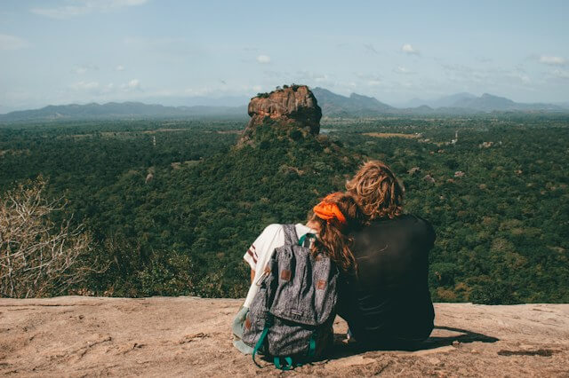 a couple sitting in front of Sigiriya rock in Sri Lanka. 