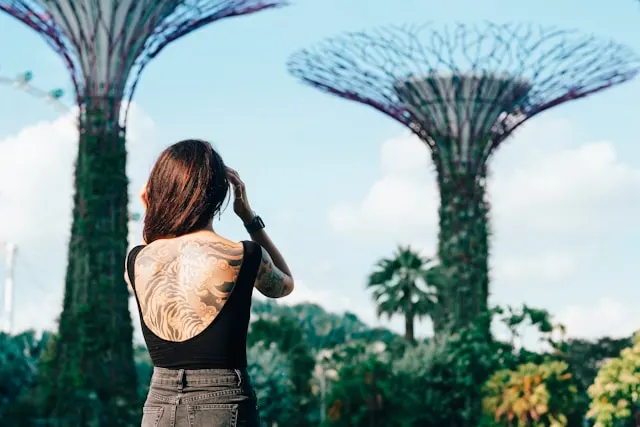 a tattooed lady standing around Gardens by the Bay in Singapore. 