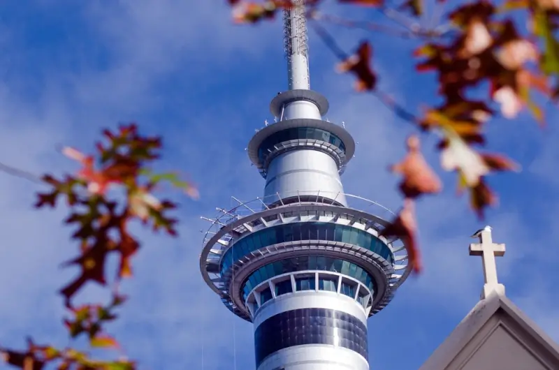Auckland Sky Tower observation decks and restaurant levels against blue sky, New Zealand's tallest structure and must-see Auckland attraction