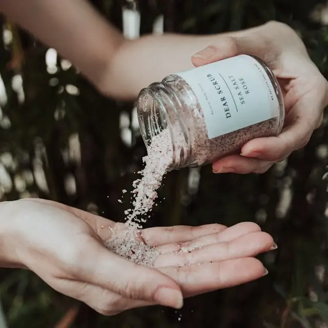 Hands pouring exfoliating scrub for weekly healthy skin tips routine to remove dead skin cells