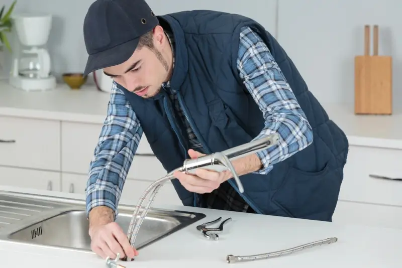 Water damage restoration technician testing kitchen sink equipment during professional repair