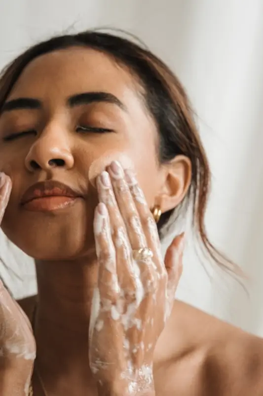Woman gently cleansing face with foam demonstrating gentle daily healthy skin tips routine