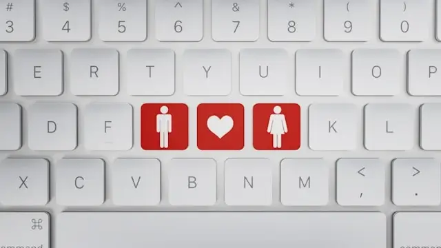 White computer keyboard with three red keys showing male figure, heart symbol, and female figure representing online dating and romance scams