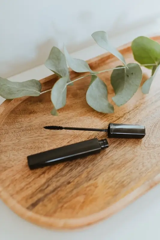 Organic-styled mascara for lash growth arranged with botanical elements on wood surface