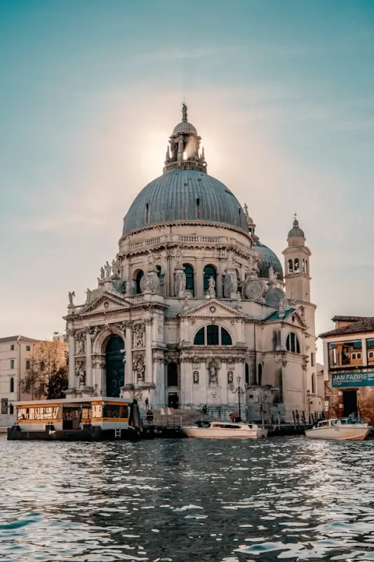 Santa Maria della Salute basilica with baroque dome and water taxis on Grand Canal - iconic Venice travel guide landmark