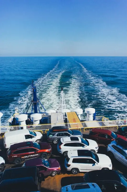 Cars loaded on ferry deck for shipping across blue ocean waters during road trip transportation
