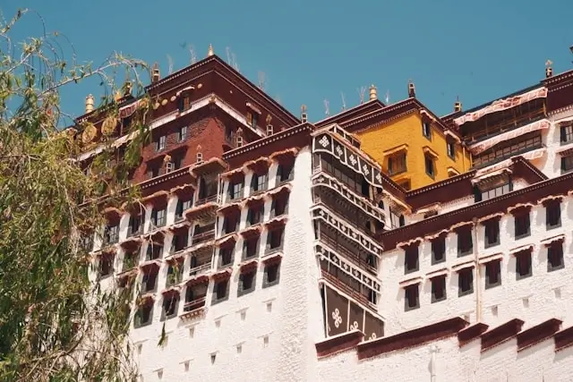 Traditional Tibetan architecture featuring multi-story buildings with ornate wooden balconies and colorful facades showcasing authentic cultural design in hospitality and tourism