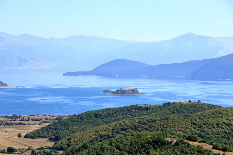 Panoramic view of Adriatic coastline with forested hills and mountain ranges in the Albanian Prespa National Park, ideal landscape for coastal hiking and outdoor adventures