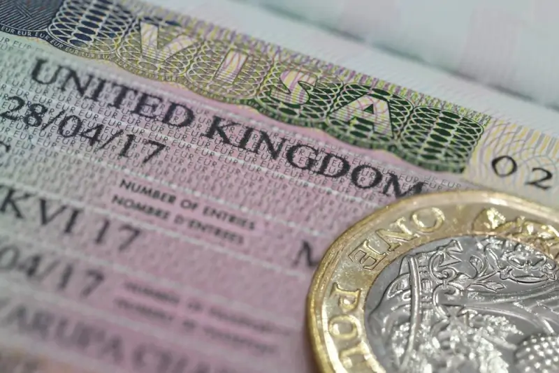 UK visa document with British pound coin showing immigration requirements for freelancers working legally in United Kingdom