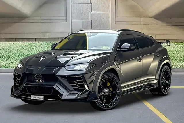 Black Lamborghini Urus with yellow brake calipers in underground parking garage demonstrating luxury vehicle needing specialized car insurance