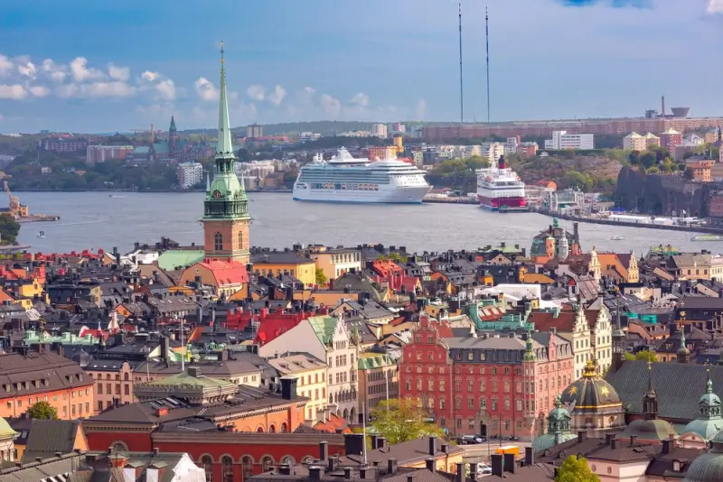 Cruise ships docked in Stockholm harbor with historic Gamla Stan old town featuring colorful buildings and church spires, showcasing Northern Europe destinations from Southampton UK cruises