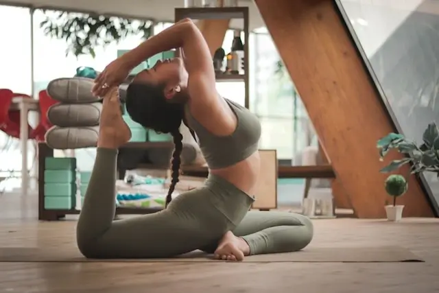 Woman practicing yoga and mindfulness exercises at home for self-care and building body confidence