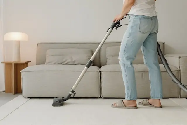 Professional cleaning service vacuuming holiday rental property living room for Cotswolds tourism accommodation maintenance