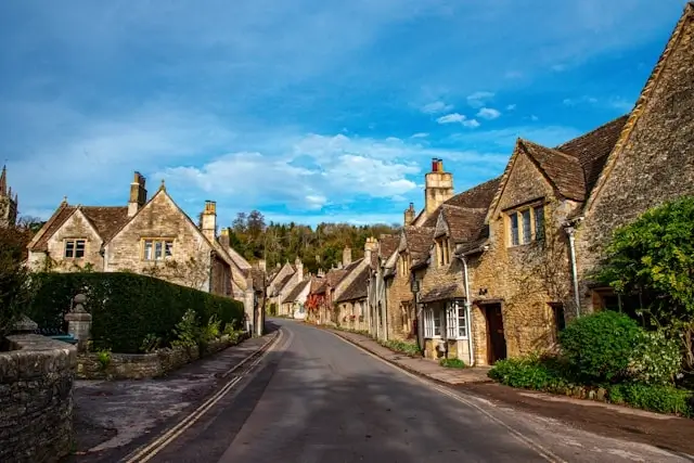 Traditional Cotswolds village street lined with historic honey-stone cottages attracting Cotswolds tourism and holiday let guests