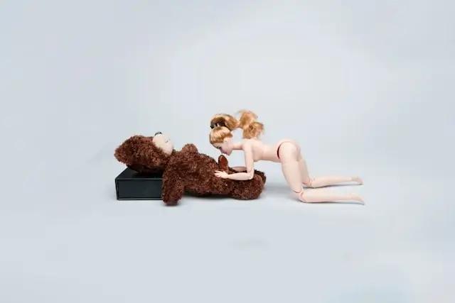 Baby doll examining teddy bear with stethoscope, representing curiosity and learning about bodies and health