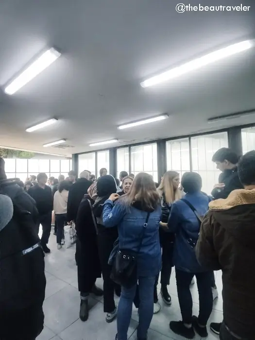 Crowded waiting area inside Sarpi border terminal with travelers during Turkey-Georgia border crossing immigration process