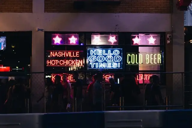 Nashville Printer's Alley nighttime scene with neon bar signs and crowds perfect for bachelorette party bar hopping