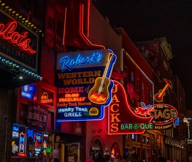 Nashville honky-tonk bars with colorful neon guitar signs on Broadway creating perfect bachelorette party nightlife atmosphere