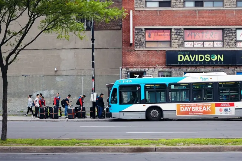 Passengers boarding STM public bus in Montreal after completing ottawa to montreal by bus journey in Quebec