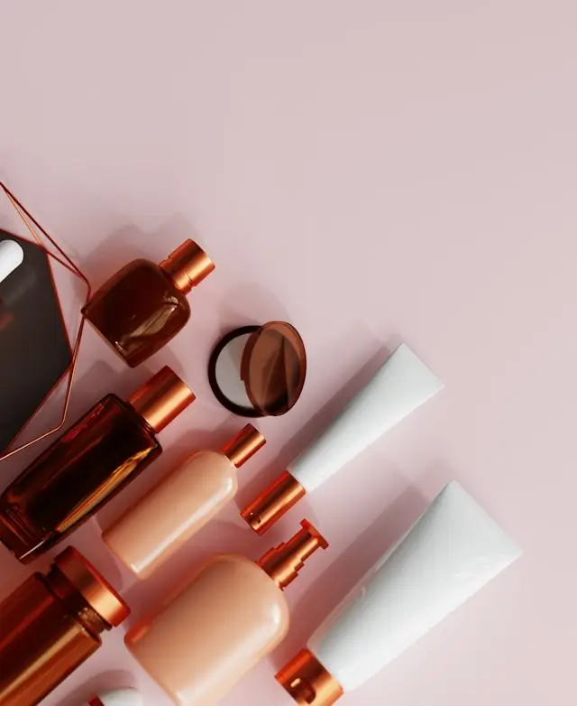 Luxury private label skincare products with rose gold caps and white tubes arranged on pink background for branding showcase