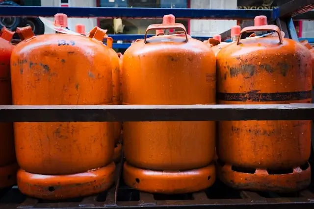 Orange propane gas cylinders stacked on shelves showing LPG alternative fuel storage
