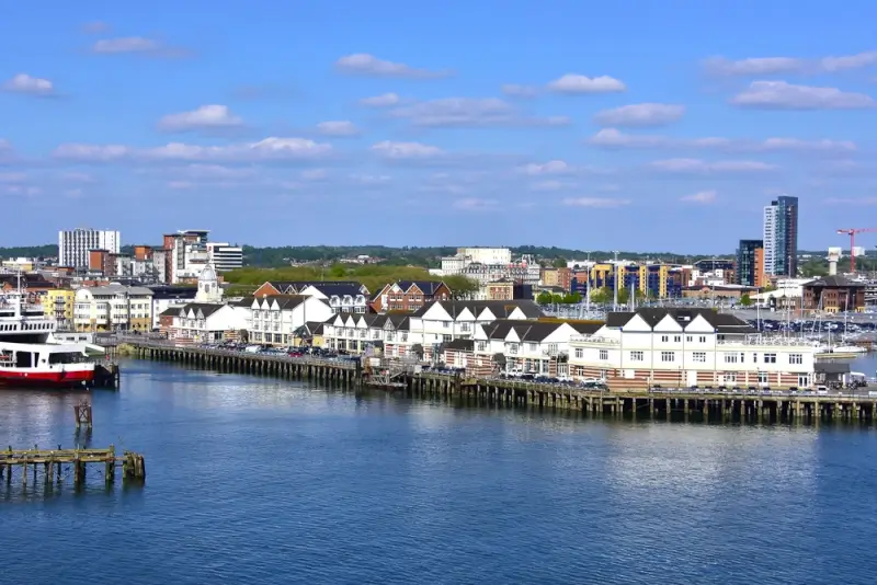 Southampton waterfront with historic pier buildings and modern city skyline, showing the UK's premier cruise port and gateway to European destinations