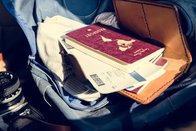 Passport and travel documents in leather bag with camera for international road trip