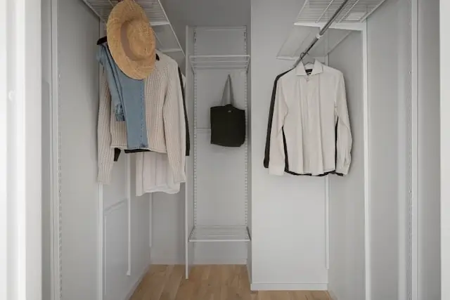 Organized minimalist closet with clean white storage system showing simplified wardrobe and decluttered space