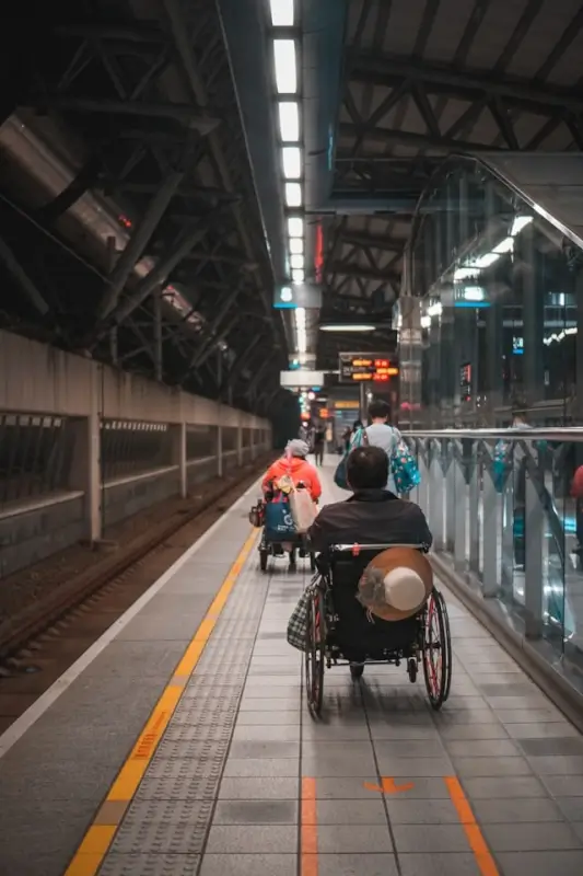 Travelers with mobility needs at train station platform showing importance of reliable protection during public transit