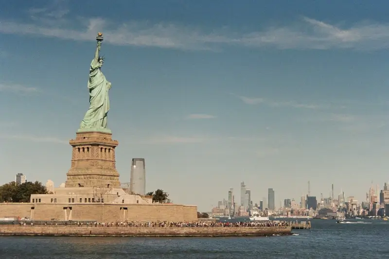Statue of Liberty with Manhattan skyline in background representing opportunity for high achievers moving to USA