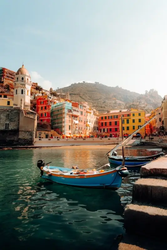 Colorful buildings and fishing boats in Vernazza harbor, Cinque Terre Italy - Instagram-worthy coastal village view