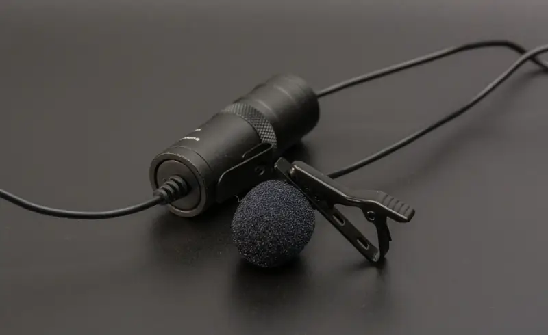 BOYA BY-M1 wired lavalier microphone with clip and foam windscreen on dark surface - best entry-level mic for vloggers