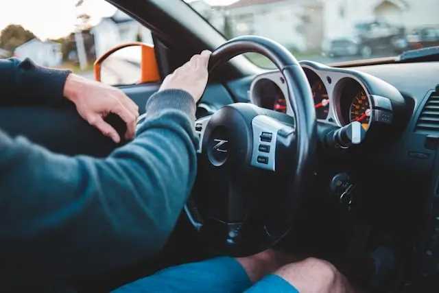Driver's hands on steering wheel inside car, representing driver responsibility and negligence factors evaluated in California car accident lawsuit cases