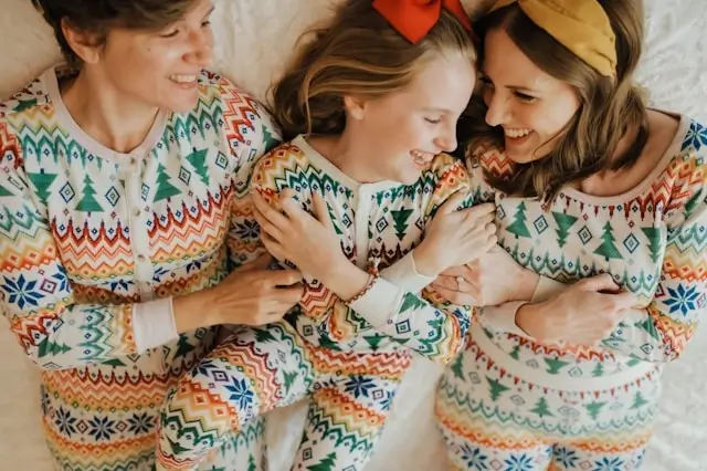 Mother and daughters wearing matching colorful Fair Isle Christmas pajamas with festive Nordic pattern design